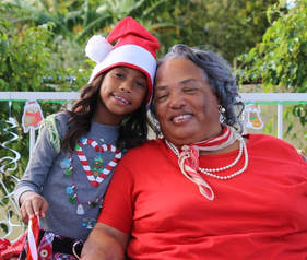 Picture of grandmother and granddaughter dressed in Christmas clothes
